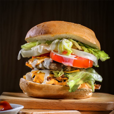 Juicy cheeseburger with fresh lettuce, tomatoes, melted cheese, and crispy fries